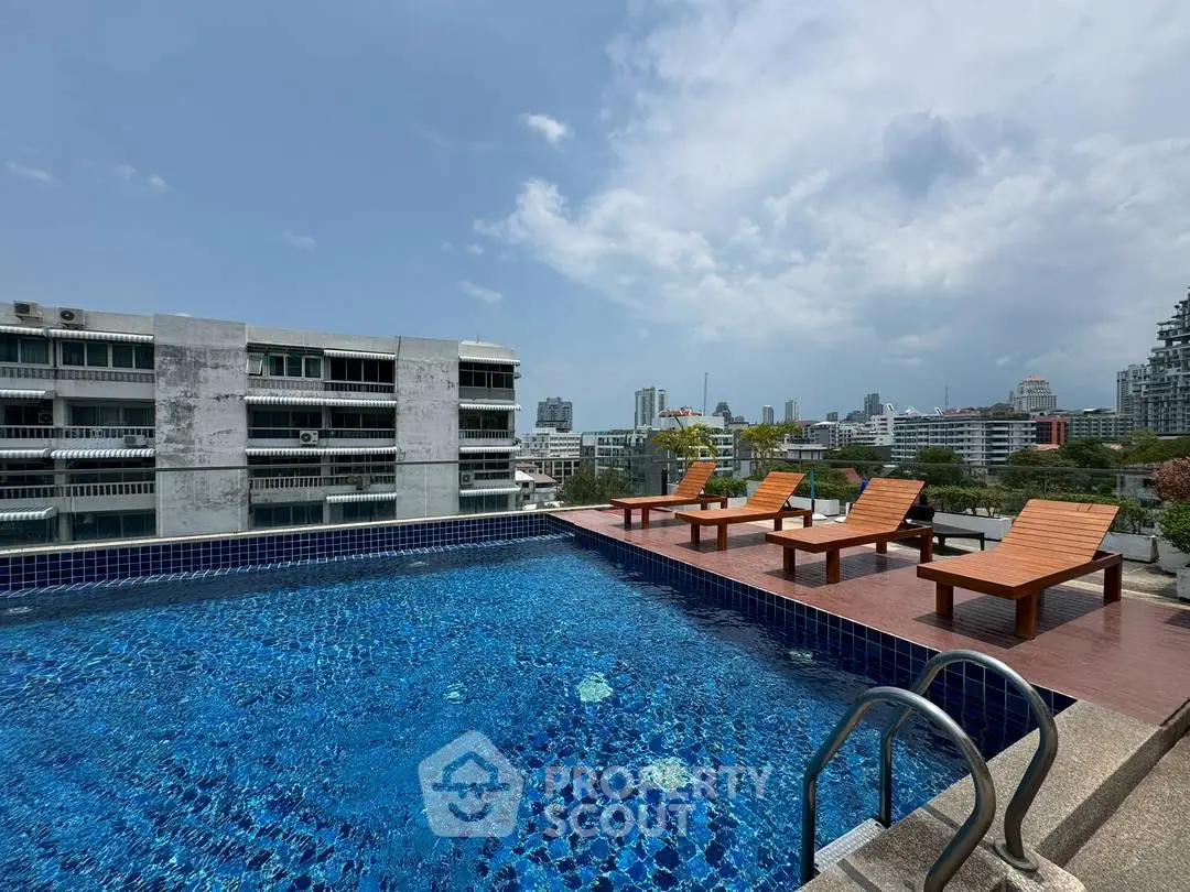 Stunning rooftop pool with city skyline views and modern lounge chairs.
