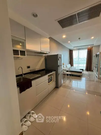 Modern open-layout kitchen and living room with sleek design and natural light.