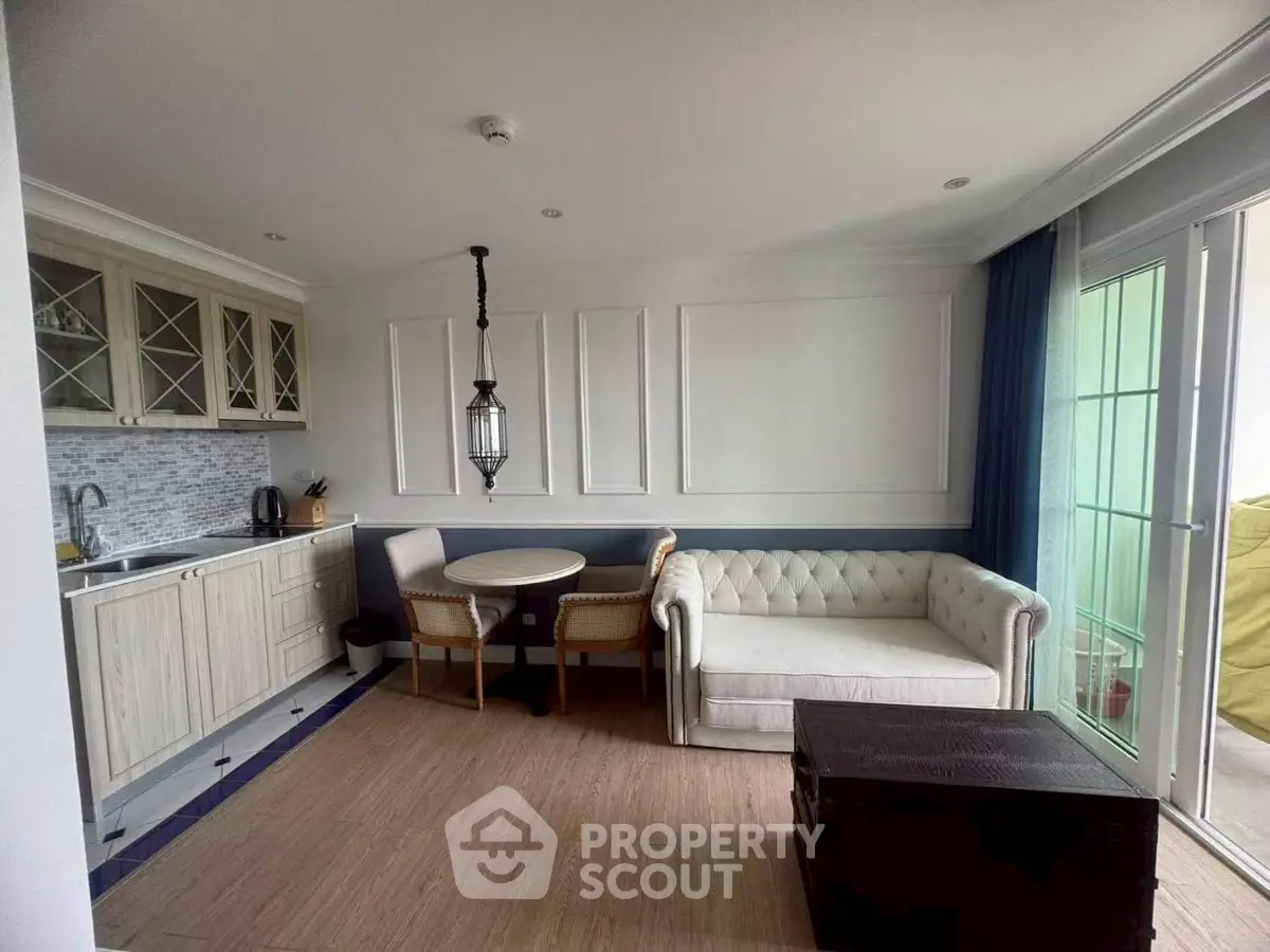 Charming living room with elegant kitchen and cozy seating area, perfect for modern living.