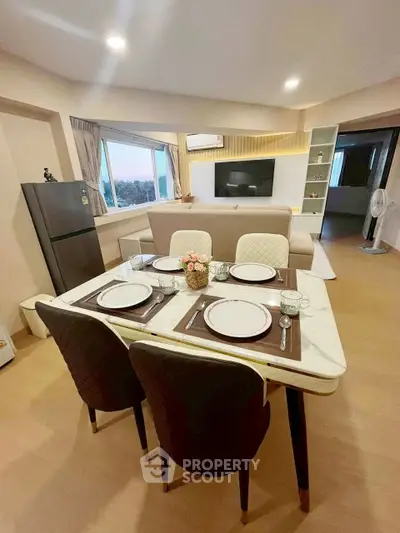 Modern living room with dining area and large windows offering a scenic view.