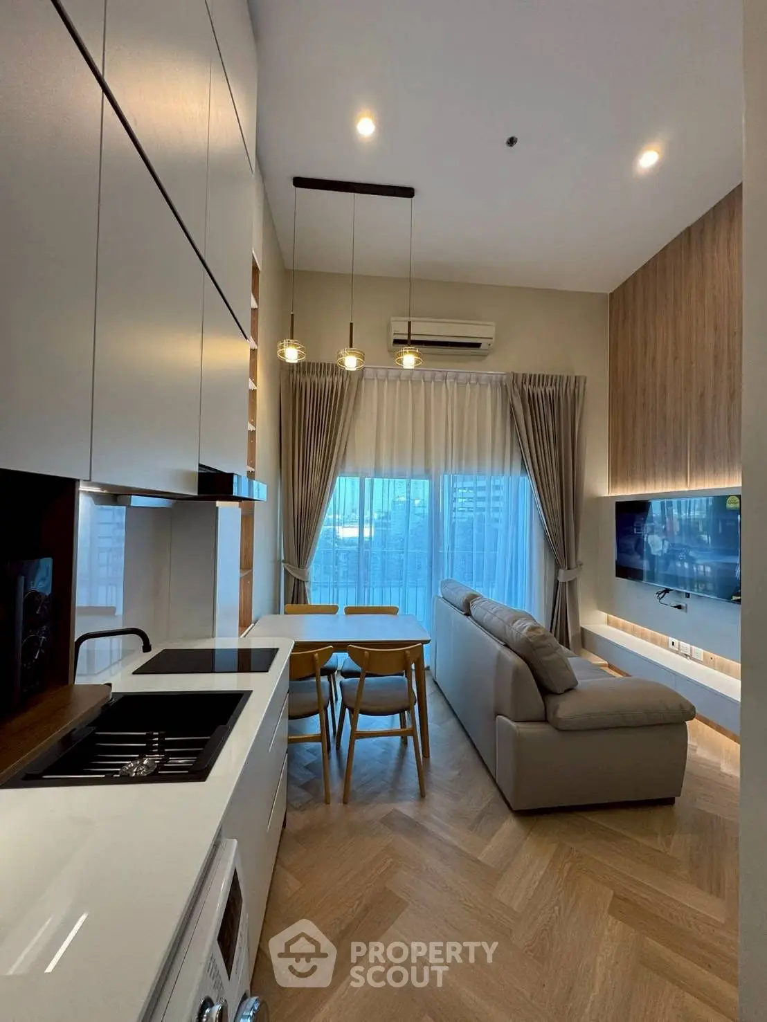 Modern open-layout kitchen and living room with stylish decor and natural light.