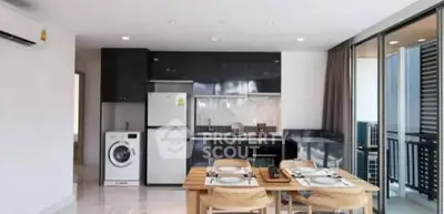 Modern kitchen with dining area, featuring sleek appliances and open layout design.