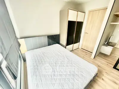 Modern bedroom with large window and sleek wardrobe in a stylish apartment.