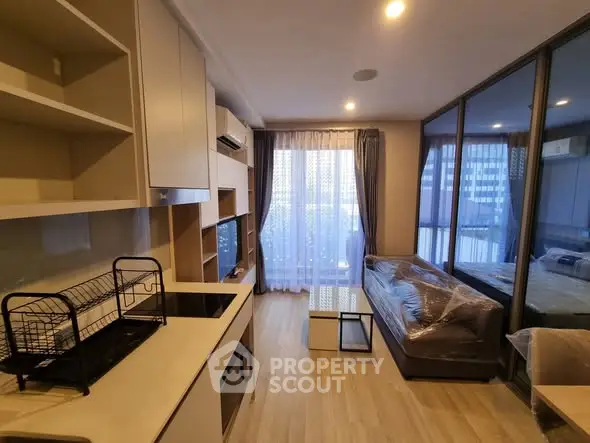 Modern living room with open kitchen and large windows in a stylish apartment.