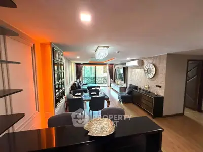 Luxurious living room with modern decor and ambient lighting, featuring a spacious layout and elegant furnishings.