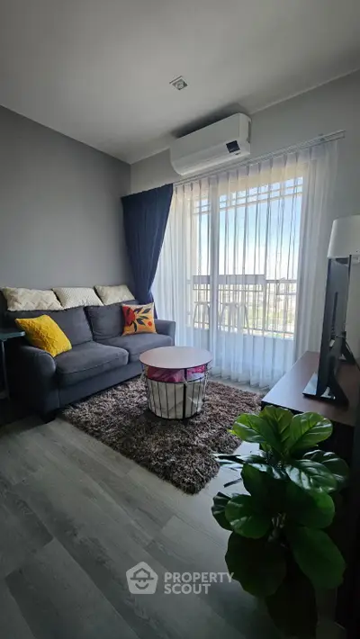 Modern living room with balcony view, stylish decor, and natural light.