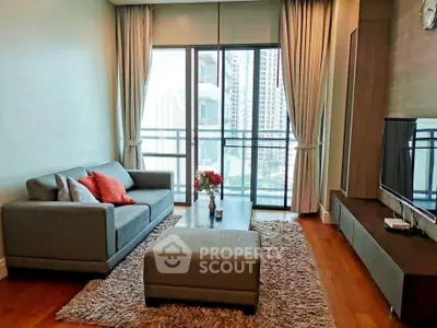 Modern living room with cozy sofa, stylish decor, and large windows offering city views.