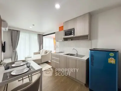 Modern open-layout kitchen and living room with natural light and stylish decor.
