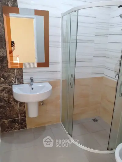 Modern bathroom with sleek shower and stylish sink in a contemporary home.