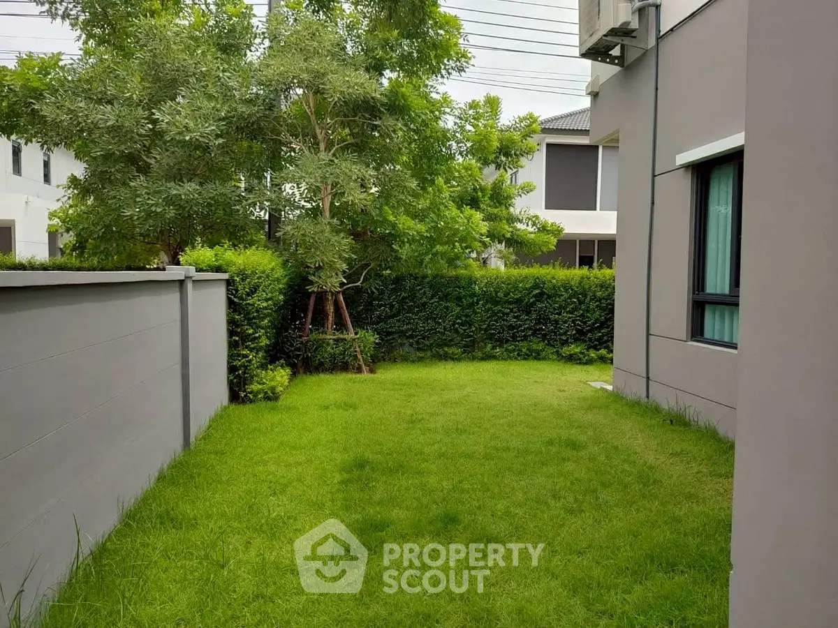 Charming garden area with lush greenery and modern architecture, perfect for relaxation and outdoor activities.