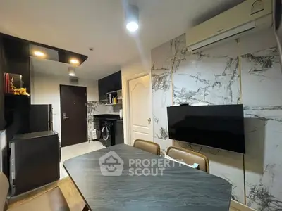Modern kitchen with sleek design, featuring marble walls, dining table, and built-in appliances.
