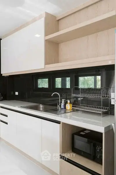 Modern kitchen with sleek cabinetry and built-in appliances, featuring a minimalist design and ample storage space.