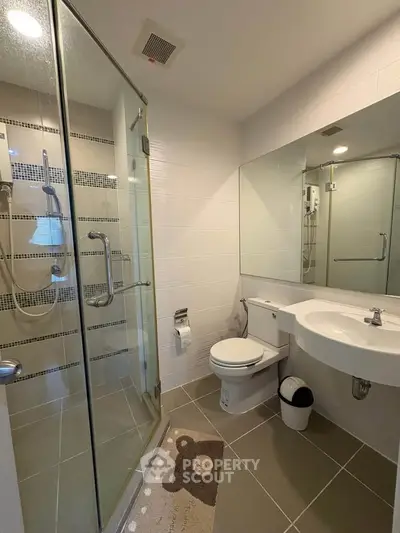 Modern bathroom with glass shower and stylish fixtures in a contemporary home.