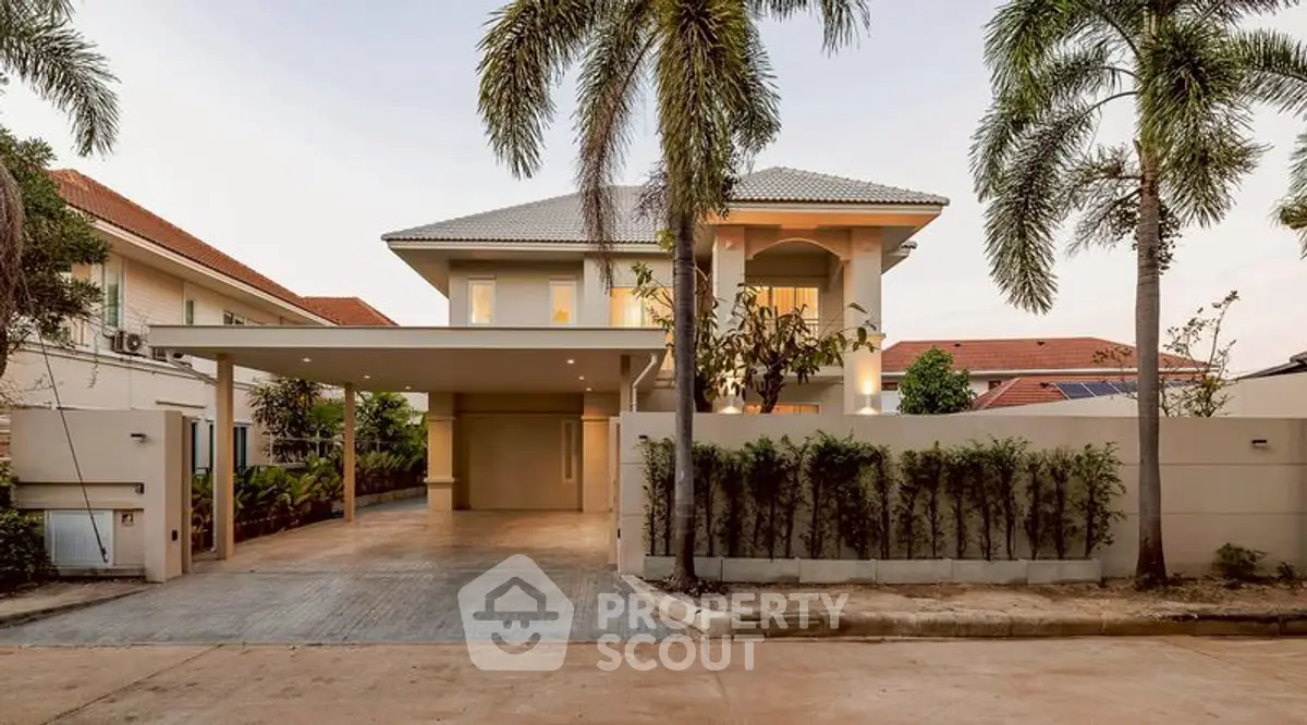 Stunning modern villa with palm trees and spacious driveway in a serene neighborhood.