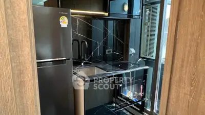 Modern kitchen with sleek black appliances and marble countertops