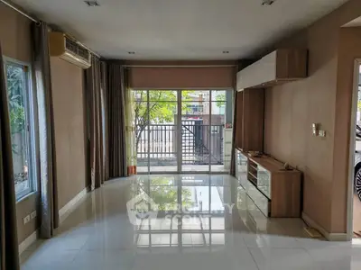 Spacious living room with large windows and modern design, perfect for natural light and comfort.