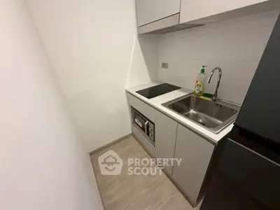 Compact modern kitchen with sleek cabinetry and built-in appliances in a minimalist design.