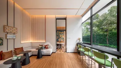 Modern living room with large windows and stylish decor, featuring a cozy seating area and lush garden view.