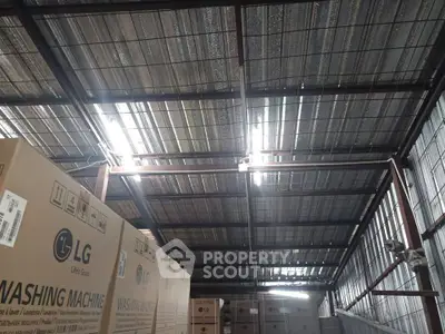Spacious warehouse interior with stacked LG washing machine boxes and industrial ceiling.