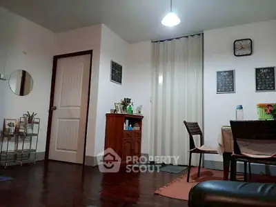 Cozy living room with dark wood flooring, stylish decor, and warm lighting for a welcoming ambiance.