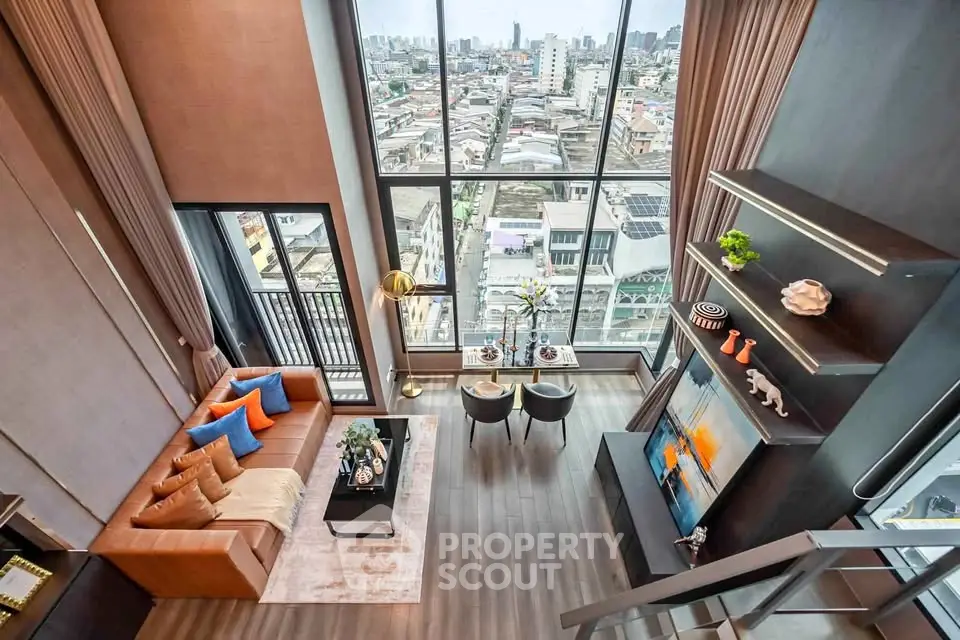 Luxurious high-rise living room with floor-to-ceiling windows and stunning city view.