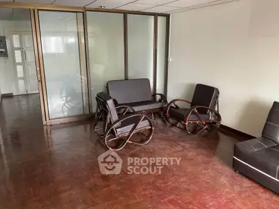 Spacious office lounge with stylish wooden furniture and glass partitions.