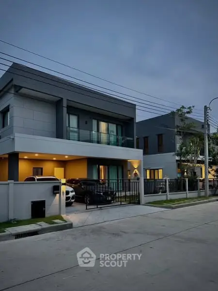 Modern two-story house with sleek design and spacious driveway at dusk.