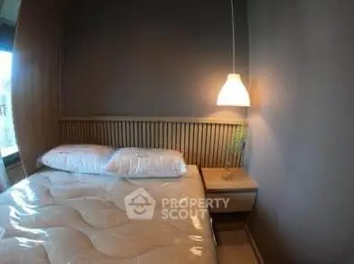 Cozy bedroom with modern lighting and stylish wooden headboard, perfect for relaxation.