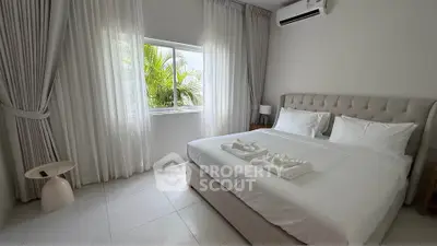 Bright and airy bedroom with large window and modern decor, perfect for relaxation.