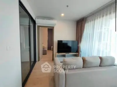 Modern living room with sleek design, large windows, and cozy seating area.