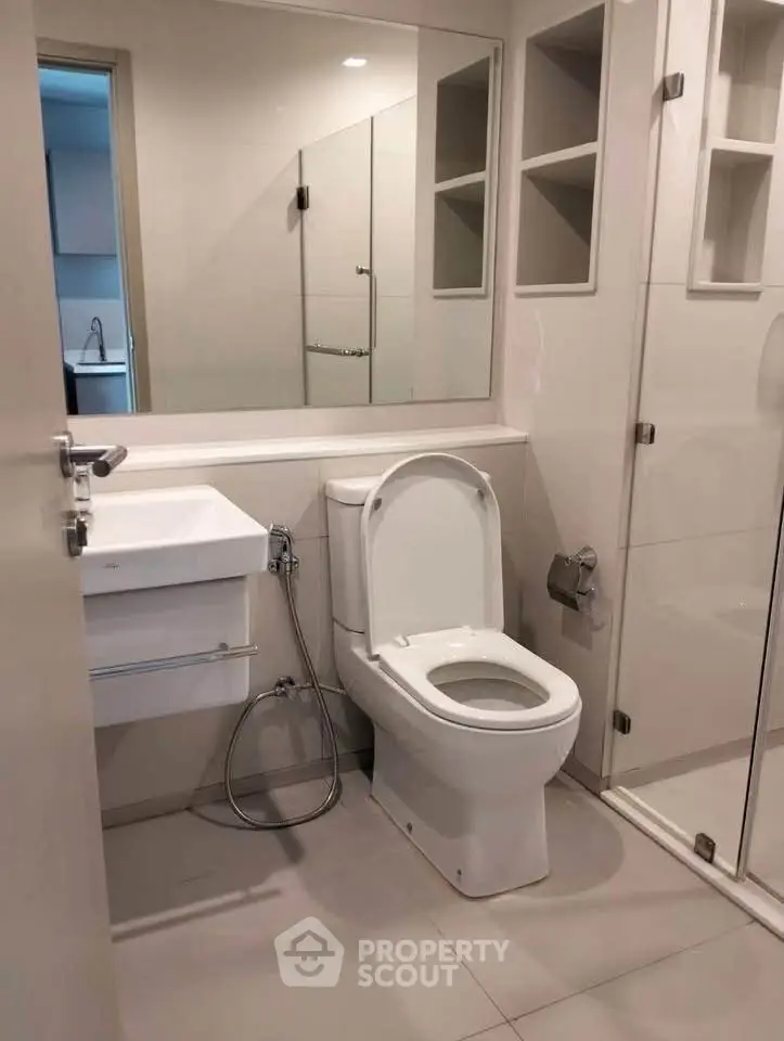 Modern bathroom with sleek fixtures and glass shower enclosure.