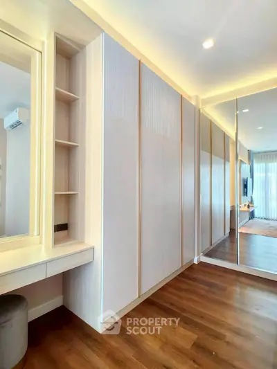 Spacious modern bedroom with elegant built-in wardrobe and wooden flooring