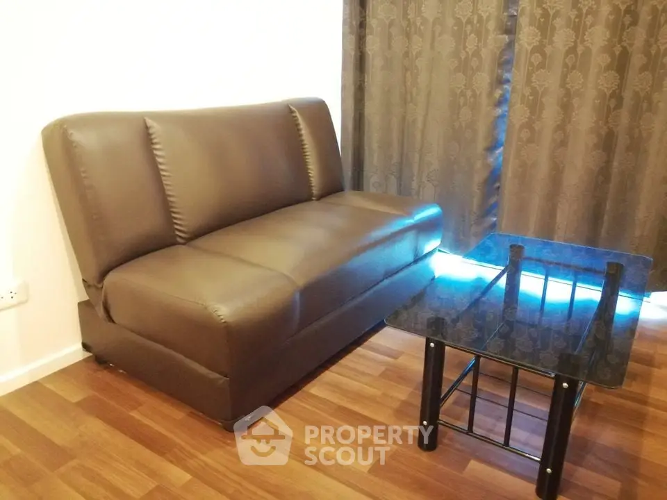Cozy living room with brown leather sofa and glass coffee table