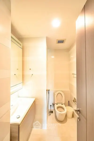 Modern bathroom with sleek fixtures and ample lighting in a contemporary apartment.