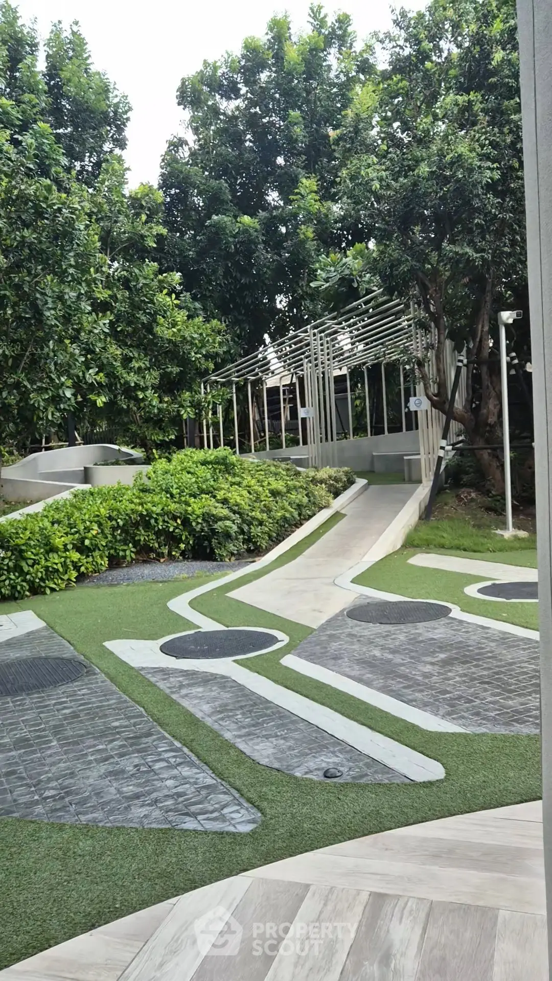Lush garden area with modern landscaping and pathways in a residential complex.