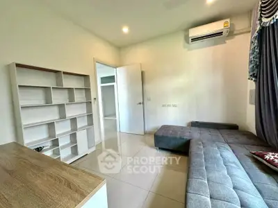 Modern living room with sleek furniture and air conditioning in a bright, minimalist design.
