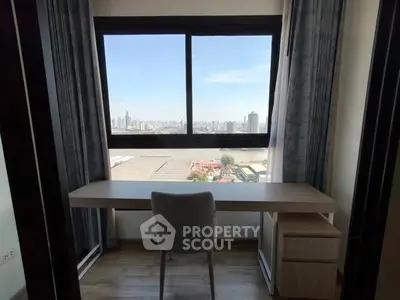 Modern study area with city view, featuring sleek desk and comfortable chair.