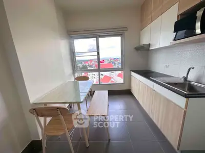 Modern kitchen with sleek cabinetry and stunning city view from large window.