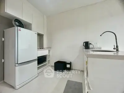 Modern kitchen with sleek appliances and minimalist design, featuring a spacious fridge and stylish countertops.