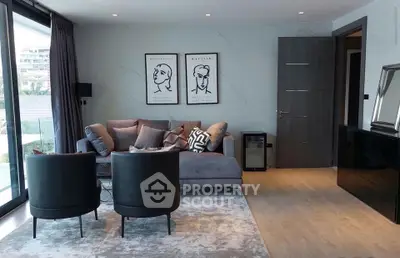 Modern living room with stylish decor and large windows offering natural light.