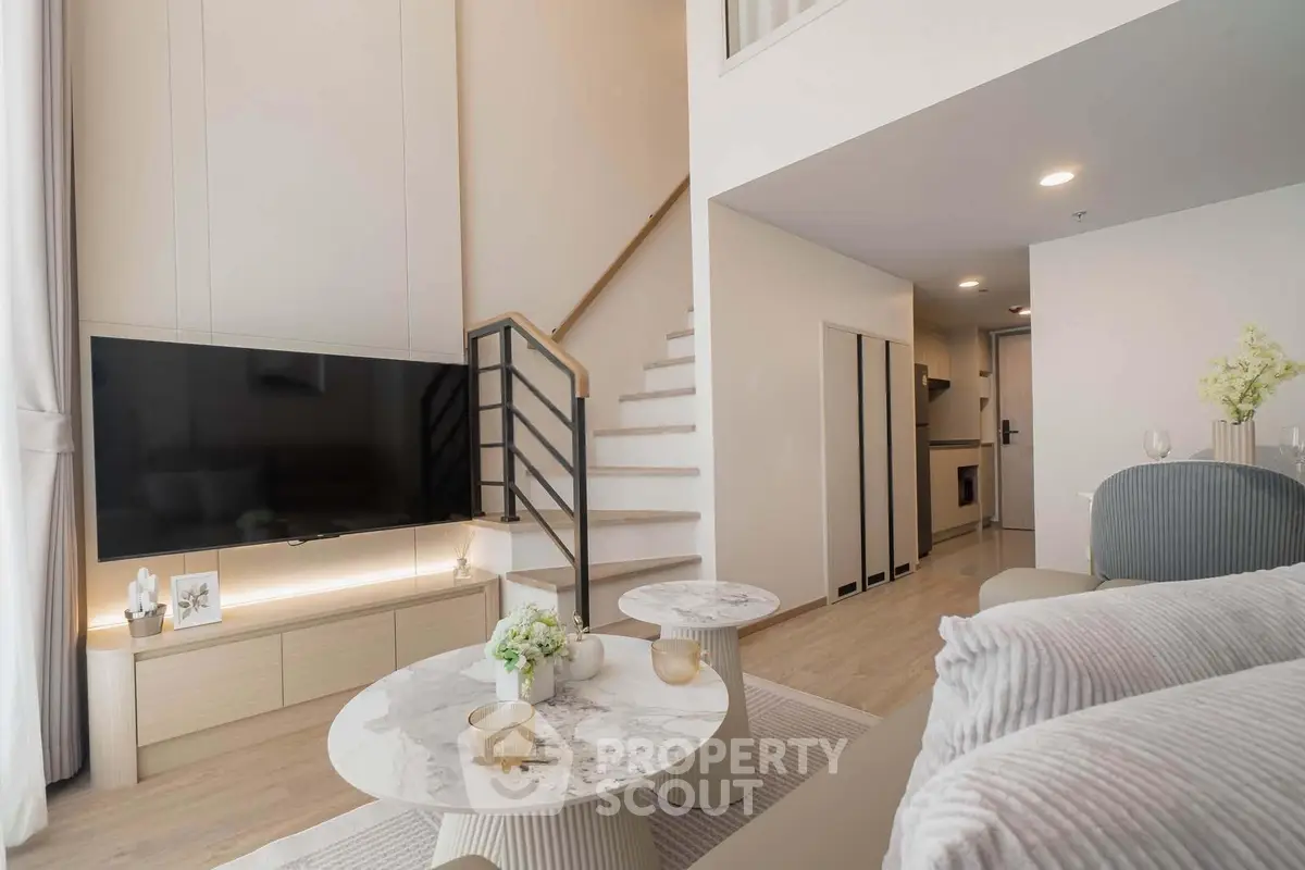 Spacious modern living room with high ceilings and elegant decor in a stylish apartment.