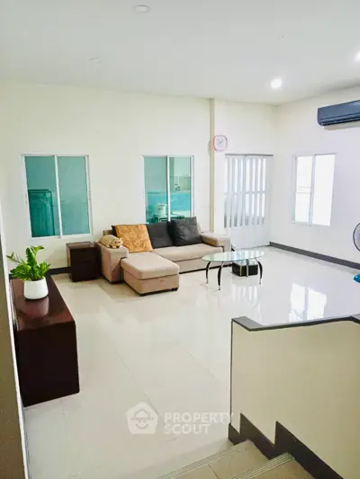 Spacious living room with modern furniture and natural light, perfect for relaxation and entertaining.