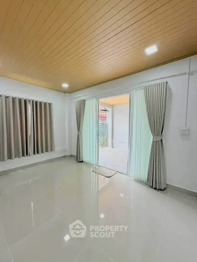 Spacious living room with modern design and large windows leading to a balcony.