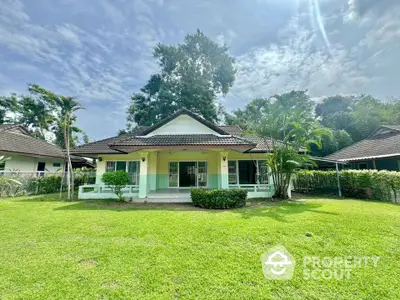 Charming single-story house with lush green lawn and tropical landscaping