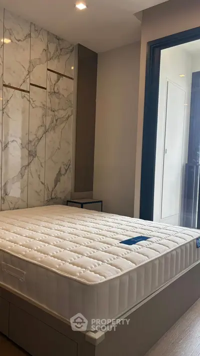 Modern bedroom with marble accent wall and comfortable mattress