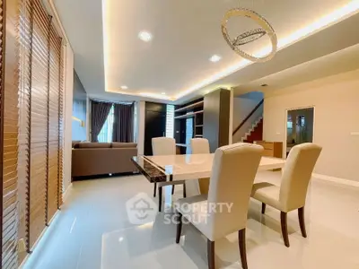 Luxurious open-plan living and dining area with elegant furnishings and modern lighting.