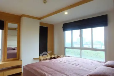 Spacious bedroom with large window offering a scenic view, featuring modern furnishings and cozy ambiance.