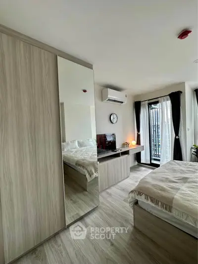 Modern bedroom with mirrored wardrobe and balcony view in stylish apartment