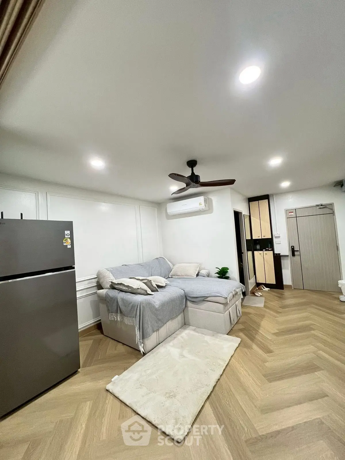 Modern living room with cozy sectional sofa and sleek refrigerator