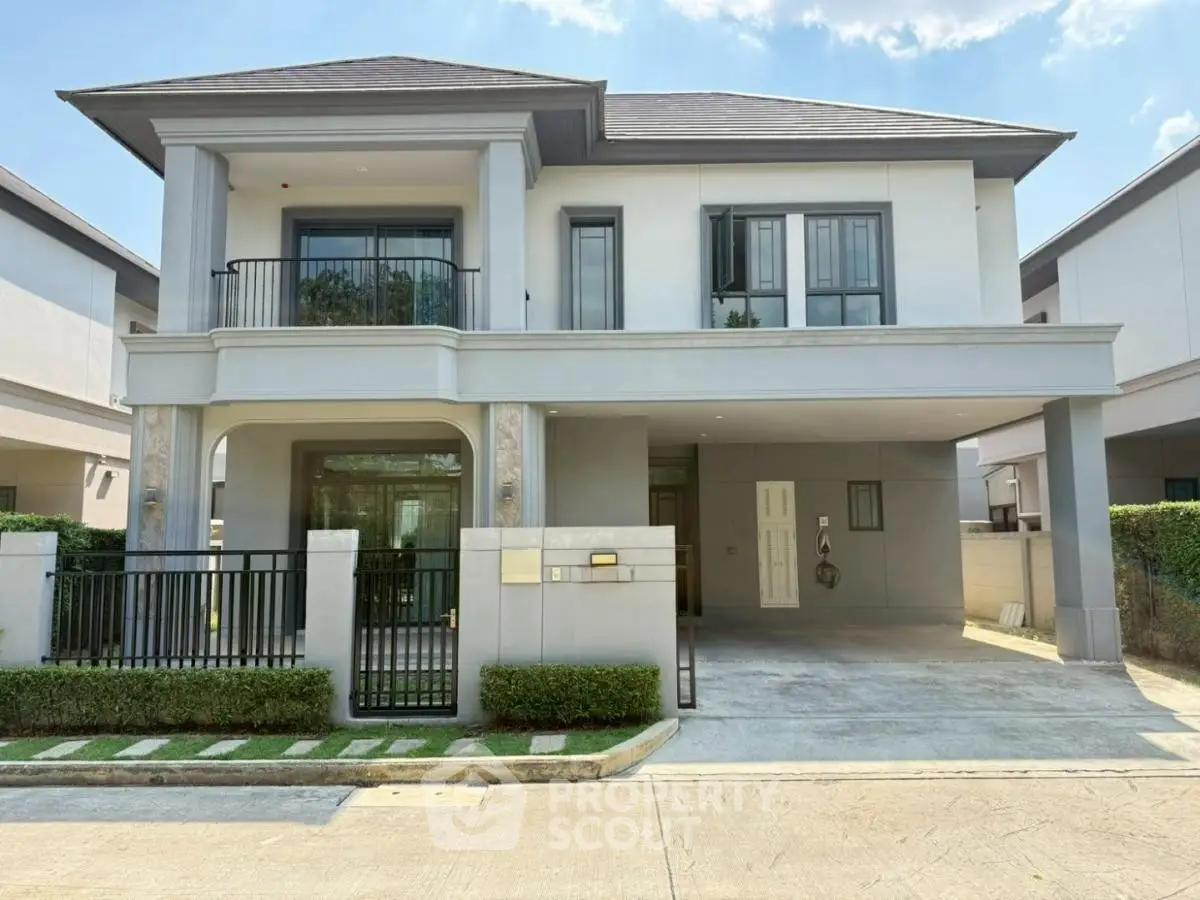 Modern two-story house with balcony and spacious driveway in a serene neighborhood.